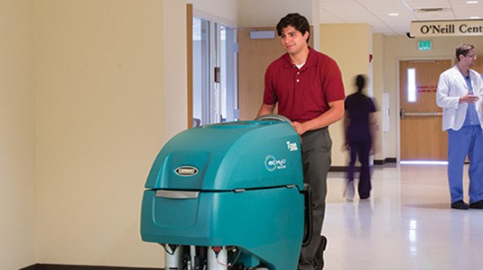 Tennant T500e lavapavimenti uomo a terra mentre pulisce l’ospedale